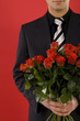 Smiling businessman with bouquet of roses in hands.