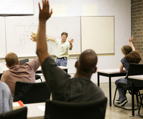 Adult education class raising hands to ask questions.