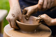 Potters hands guiding a child to help him with the ceramic wheel Potters hands guiding a child to help him with the ceramic wheel