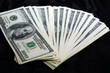 Photo: stack of USD fanned out on black satin background stack of USD fanned out on black satin background