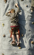 Boy climbing on an artificial rock climbing wall, 