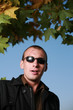 Portrait of a tough man in black sunglasses, with scars on face.