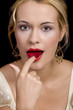 Beautiful blond girl kissing and smelling a rose petal 
