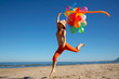 girl with colored balloons jumping on the beach girl with colored balloons jumping on the beach