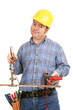 Construction worker trying to do plumbing with electrical tool