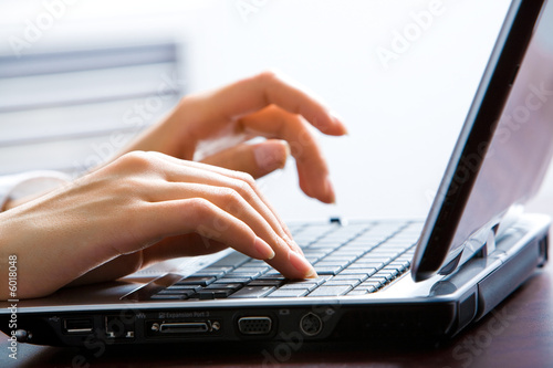 Photo: Image of female hands on the keys typing documents Image of female hands on the keys typing documents