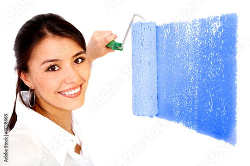 Photo: beautiful woman painting a wall with a roller - isolated beautiful woman painting a wall with a roller - isolated