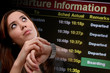 Photo: A pretty business woman traveling looking at departure times A pretty business woman traveling looking at departure times