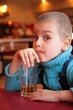 soiled boy drinks juice from glass through straw soiled boy drinks juice from glass through straw