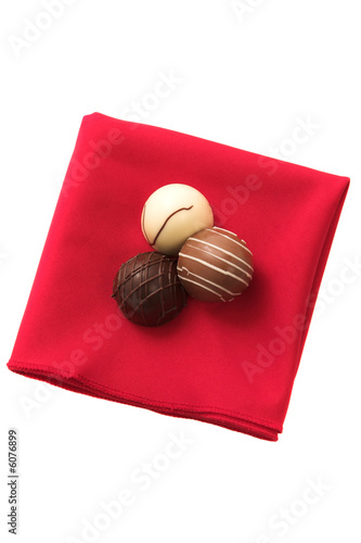 Photo: Three Chocolates on a red serviette Three Chocolates on a red serviette