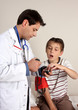 Child sitting on a treatment bed doctor takes  blood pressure