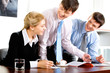 Three business people gathered together around the table 