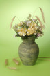 Vase with bouquets of field flowers on a green background. Vase with bouquets of field flowers on a green background.