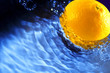 Colorful orange splashing in blue water