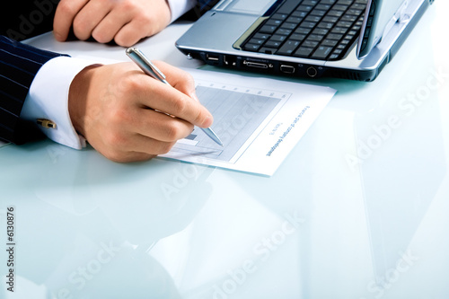Businessman’s hand ready to make notes in a document 