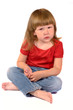 Serious kid sitting on the floor isolated on white
