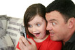 Father and young daughter play a game on her cell phone.