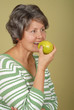 Healthy older woman enjoying a green apple