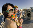 Fisheye shot of girls in brightly colored clothing on a roof 