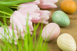 Pink tulips, fresh grass and painted wooden eggs