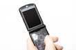 Flip mobile phone in hand, isolated on white background