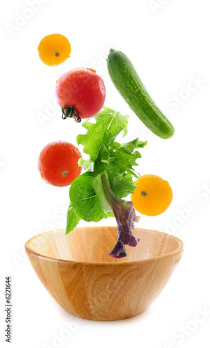 Photo: Assorted fresh vegetables falling into a wooden salad bowl Assorted fresh vegetables falling into a wooden salad bowl