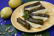 Five wine leaf rolls and fresh lemon slices with pine nuts