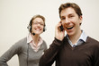 Photo: Mann und Frau telefonieren mit Hesdset und Handy und lachen Mann und Frau telefonieren mit Hesdset und Handy und lachen