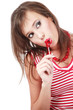 Pretty young girl with trendy makeup sucking red lollipop