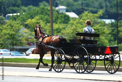 Photo: An Amish horse and buggy traveling down a Pennsylvania street. An Amish horse and buggy traveling down a Pennsylvania street.