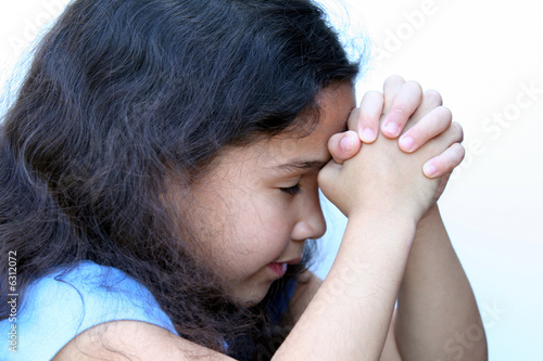 Young girl on white background who is thinking or praying