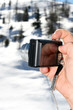 Photo camera in hand on winter background Photo camera in hand on winter background