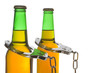 Drunk driving concept - bottled beer and handcuffs.