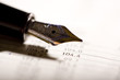 an expensive pen on a financial magazine