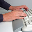 Man's hands typing on a desktop computer keyboard. Man's hands typing on a desktop computer keyboard.