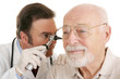 Doctor using otoscope to look in a senior man's ears.  