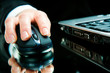 Hand over computer mouse with laptop near by