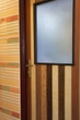 Wooden patterned door in brightly lit hallway 