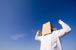 a young man with a cardboard hiding his head