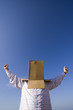 a young man with a cardboard hiding his head