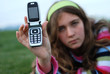 young blond girl in the park and cell phone