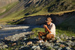 man is smoking tobacco-pipe near the stream