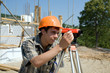 Chief of construction on a building site, looks in a level.