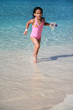 Young girl playing in the sand at the beach with a bucket Young girl playing in the sand at the beach with a bucket
