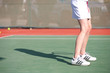 Legs of a young woman playing tennis in the sun Legs of a young woman playing tennis in the sun