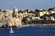 vista della costa maltese con barca a vela bianca