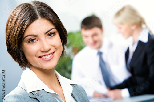 Face of beautiful woman on background of business people