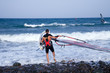 windsurfer sailing away form the beach on blue waters