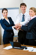 Three standing business partners making a pile with hands Three standing business partners making a pile with hands