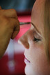 A young woman has makeup applied before a big event